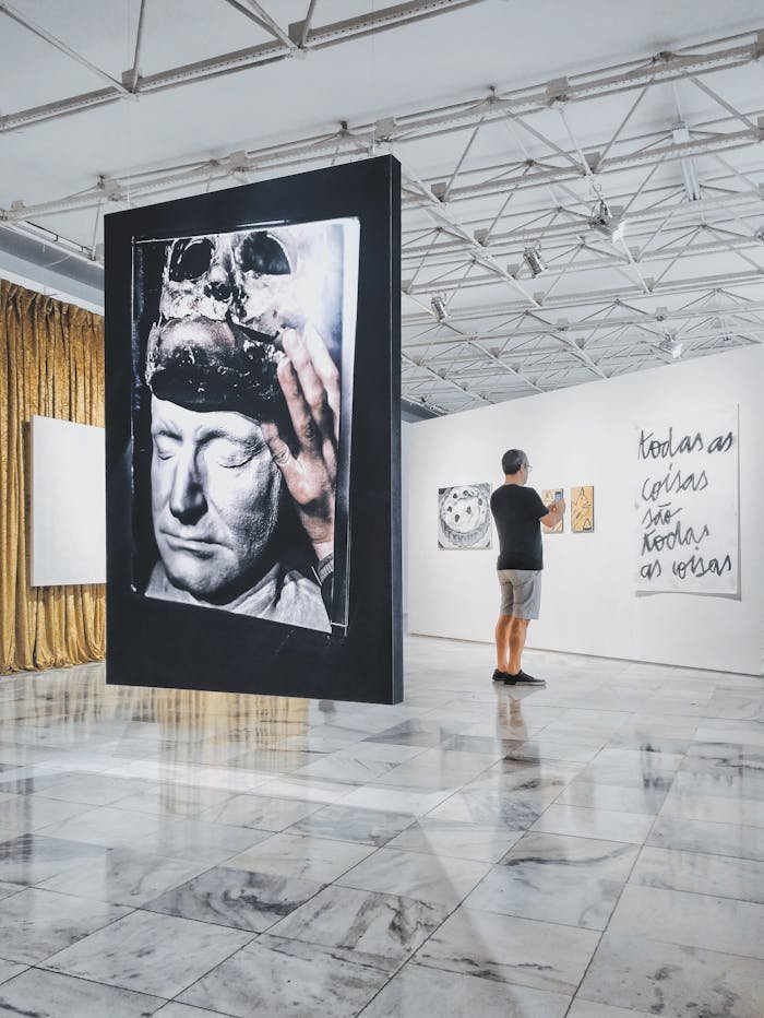 A visitor admires contemporary art pieces in a modern Brazilian gallery.